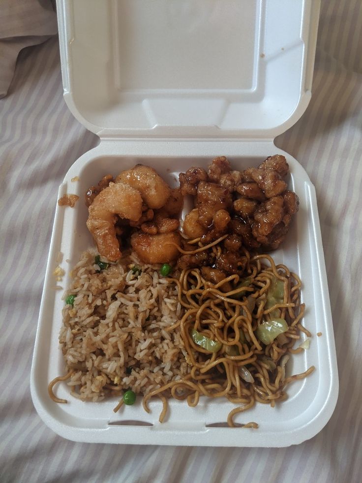 a takeout box filled with noodles and shrimp