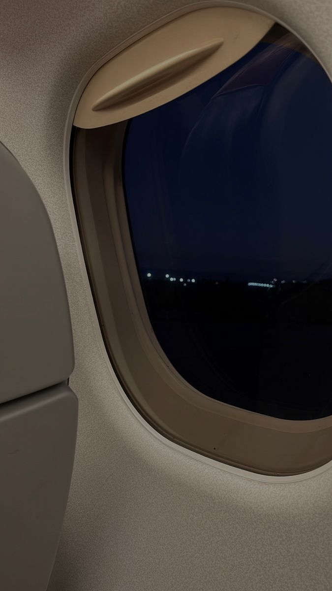 an airplane window with the night sky seen through it's sidewalls, as seen from inside