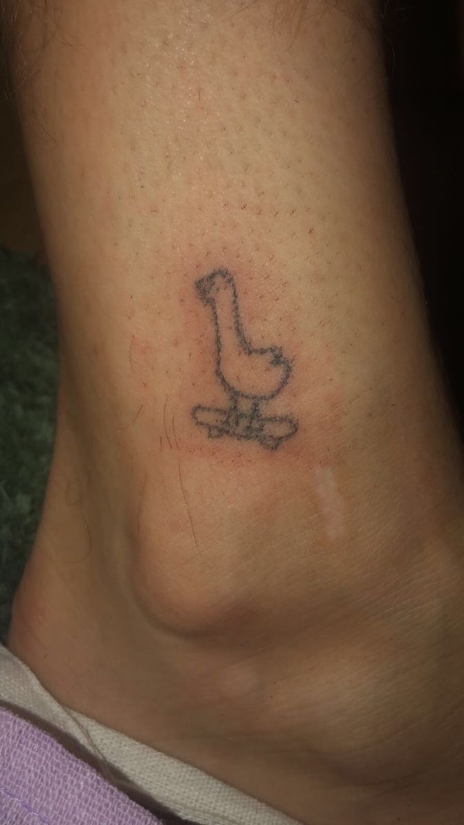 a person with a small tattoo on their neck and foot is sitting in front of the camera