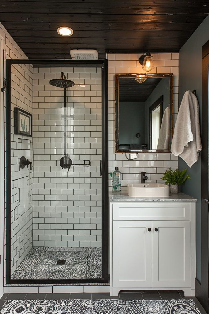 a bathroom with a walk in shower next to a white sink and mirror on the wall