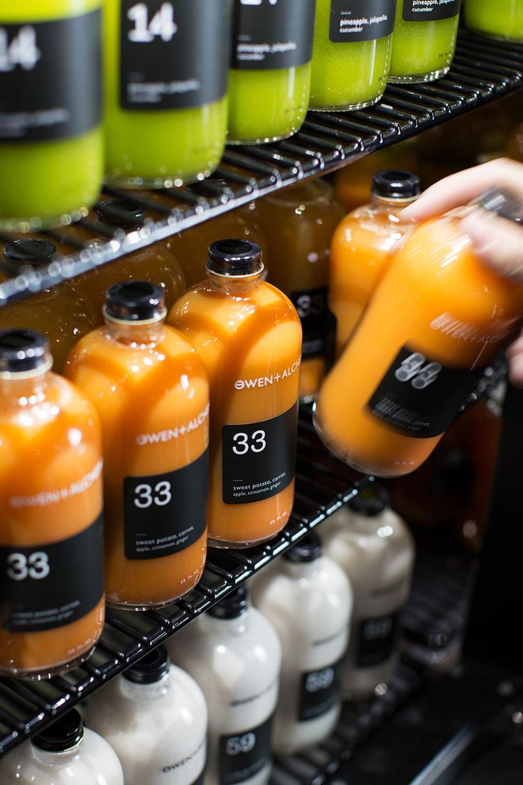 a person is pouring orange juice into bottles