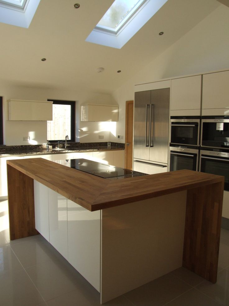 a large kitchen with an island in the middle and skylights on the ceiling above it