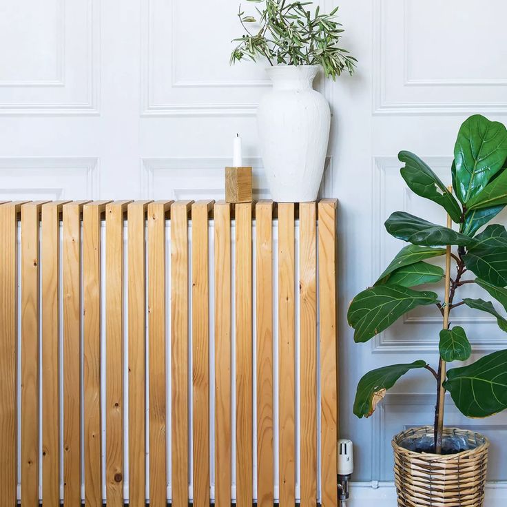 a potted plant sitting on top of a wooden radiator