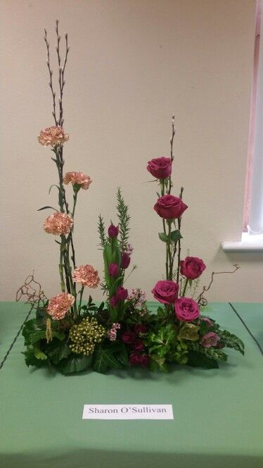 a green table topped with lots of flowers