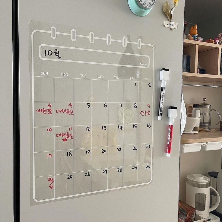 a refrigerator with a calendar on the door and magnets attached to it's side