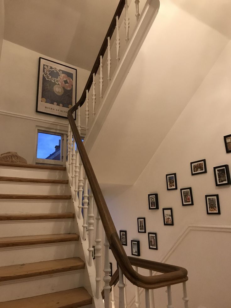 there is a stair case with pictures on the wall and framed photos on the wall