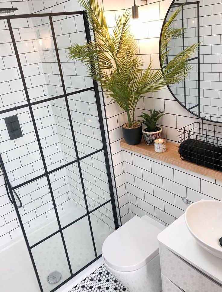 a bathroom with white tile and black accents