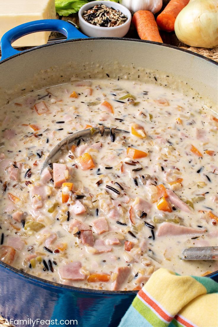 a blue pot filled with soup next to vegetables