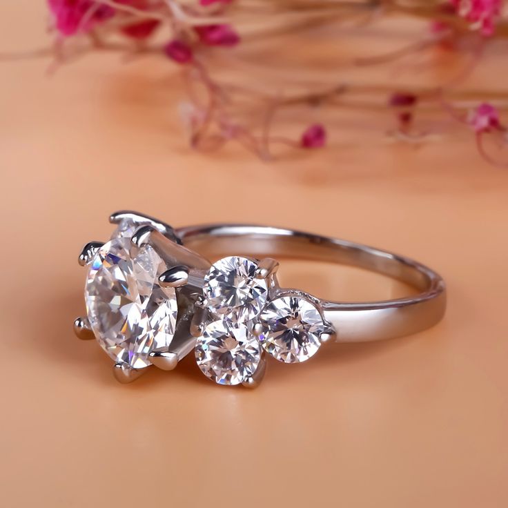 Glistening and glamorous, this engagement ring will win her heart. It features a sparkling round cut center stone and trio of round stones flank each side. An awesome look of love, this engagement ring is certain to leave her spellbound. All the stones sparkle perfectly from every angle,making the ring an eye-catcher everywhere. Carat Weight: 3.5 ctStone Size: 8 mmStone Type: Jeulia® StoneNumber of Stones: 1 Stone Color: Diamond WhiteStone Shape: RoundCarat Weight: 9 ctStone Size: 6 mmStone Type: Jeulia® StoneNumber of Stones: 6 Stone Color: Diamond WhiteStone Shape: RoundWeight: 4 gWidth: 2.5 mmMaterial: 925 SilverPlating Color: Silver Sterling Silver Rings Simple, Diamond Ring Wedding, Look Of Love, Silver Ring Designs, Couple Wedding Rings, Ring Settings, Diamond Fashion Rings, Moissanite Diamond Rings, Stomach Fat