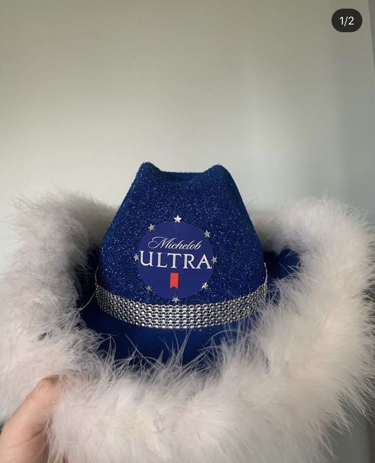 someone is holding up a blue hat with white fur around it that says, michael ultra