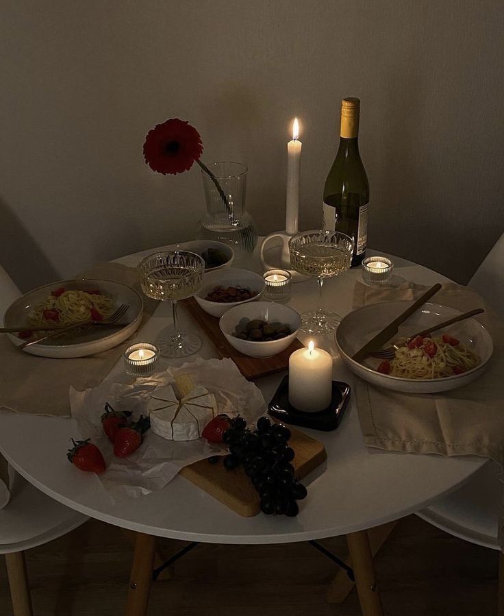 the table is set with food, wine and candles