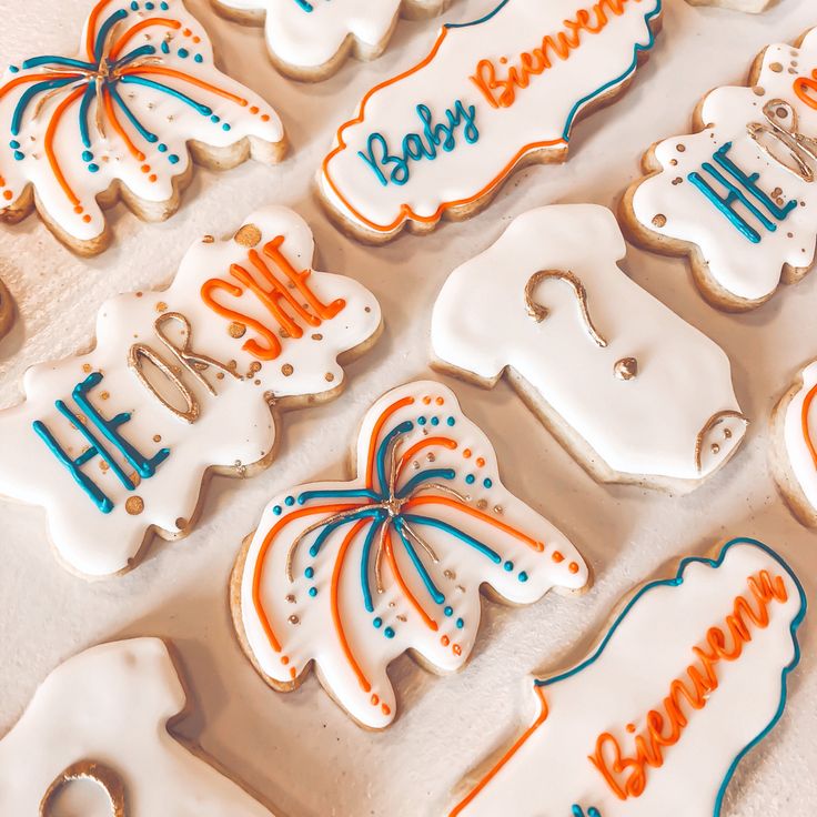 decorated cookies are arranged in the shape of baby's name and birth month letters