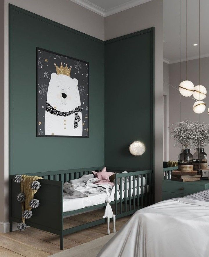 a baby's room with a green wall and white bed in the corner, an art piece hanging on the wall