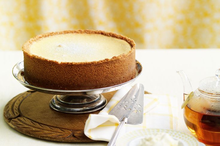 a cake on a plate next to a tea pot