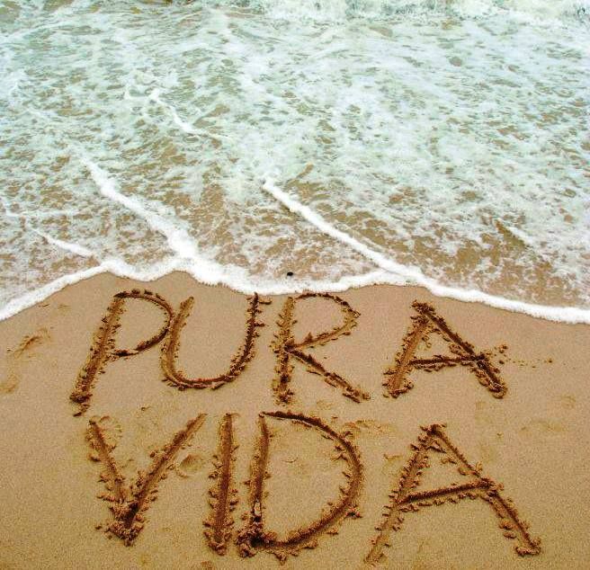 the word pura vida written in sand on a beach next to the ocean