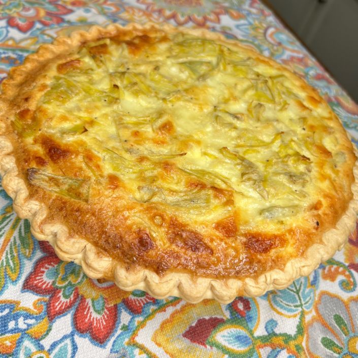 a quiche sitting on top of a colorful table cloth