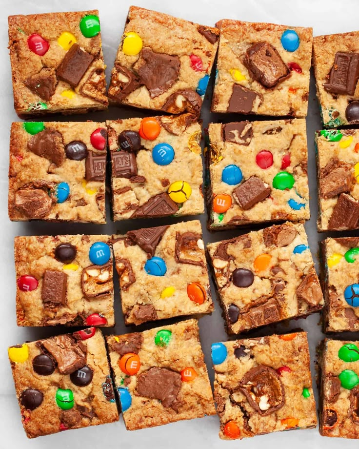 chocolate chip cookie bars with m & m candies on top are arranged in rows