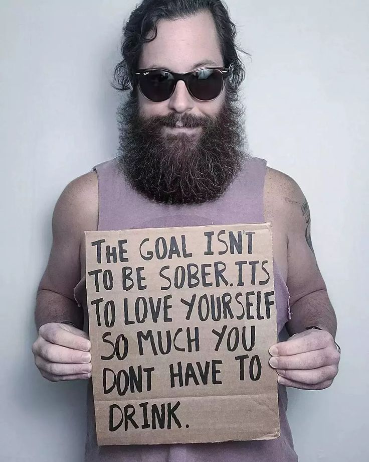 a man holding a sign that says, the goal isn't to be obeed