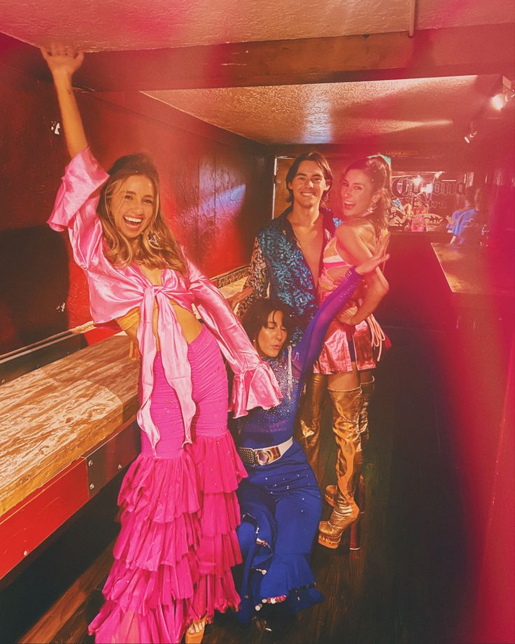 two women and one child are posing for a photo in front of a bed with other people