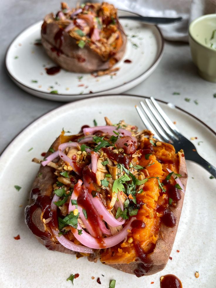 two white plates topped with food and a fork