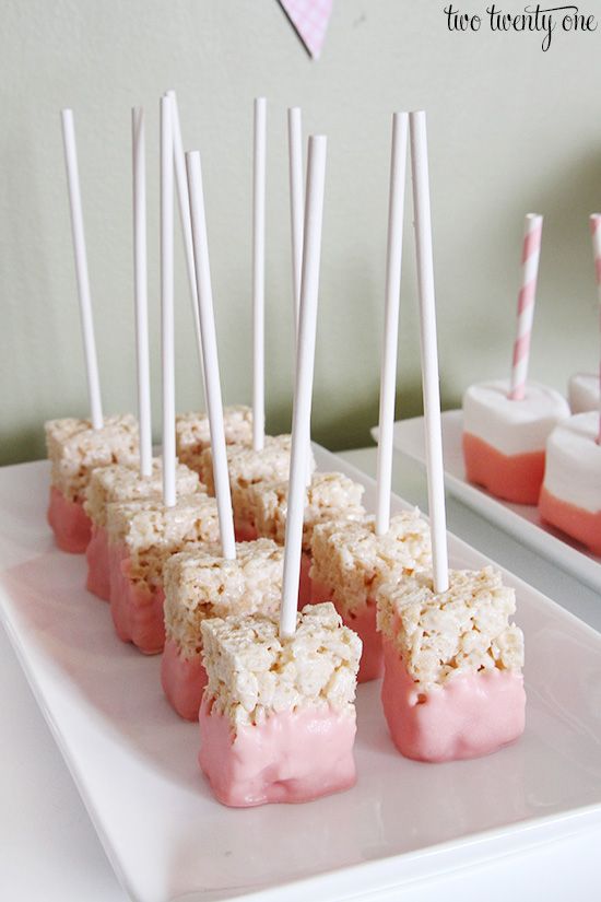 marshmallows are arranged on a white plate with pink and white striped strawberries