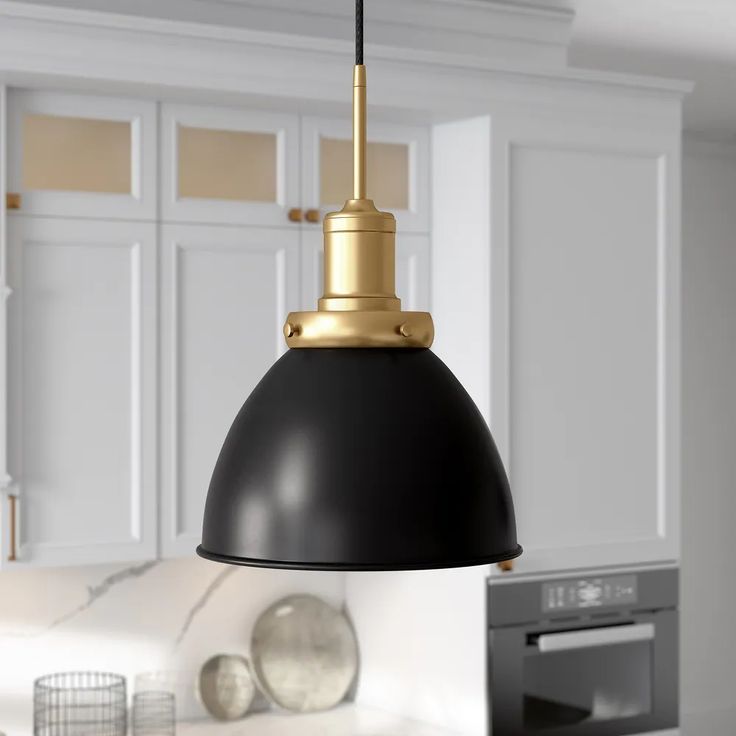 a black and gold pendant light in a kitchen