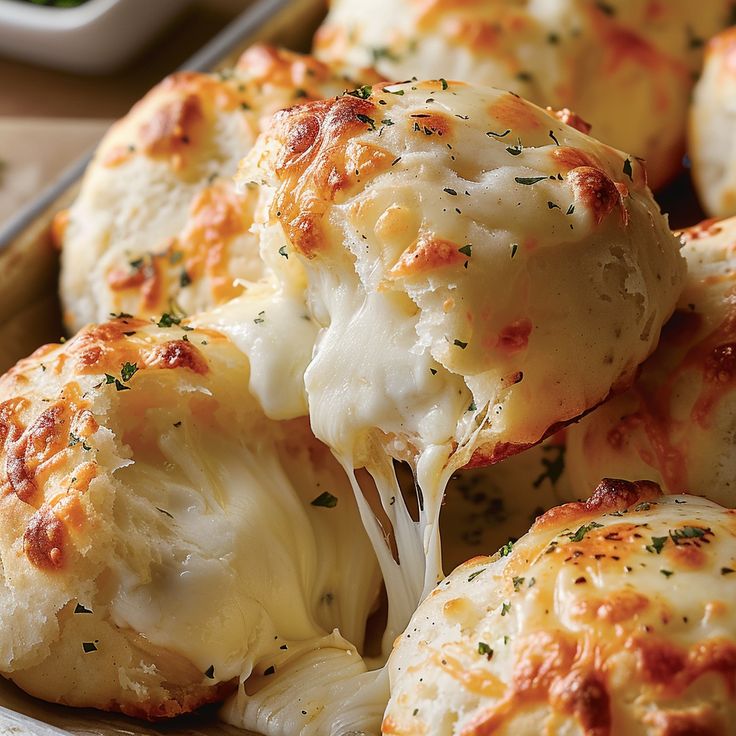 a plate full of cheese covered biscuits