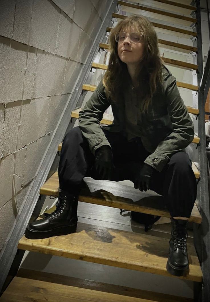 a woman sitting on top of a set of stairs