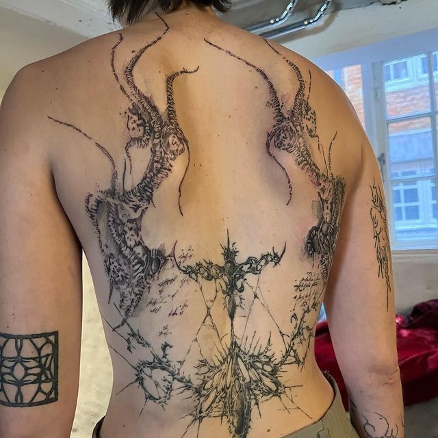 the back of a man with tattoos on his body