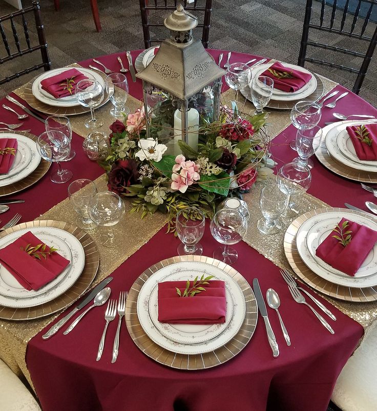 the table is set with red and white place settings