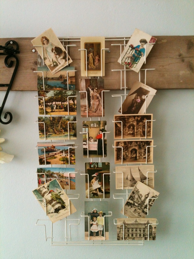 there is a wall hanging with pictures and magnets attached to the pegs on it