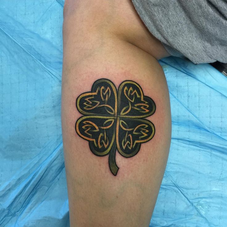 a four leaf clover tattoo on the leg