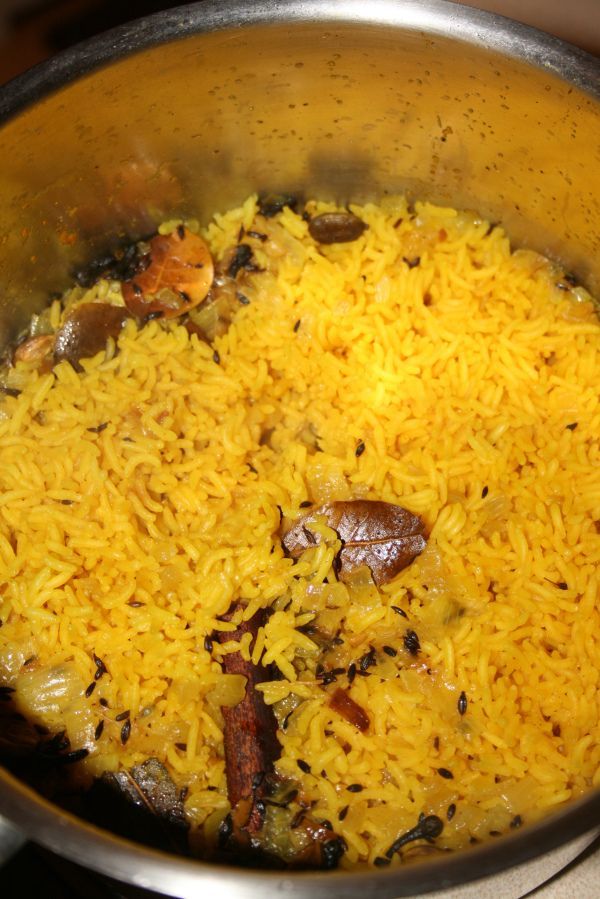 a pot filled with yellow rice on top of a stove