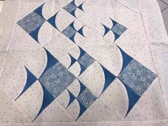 a blue and white quilt on the floor