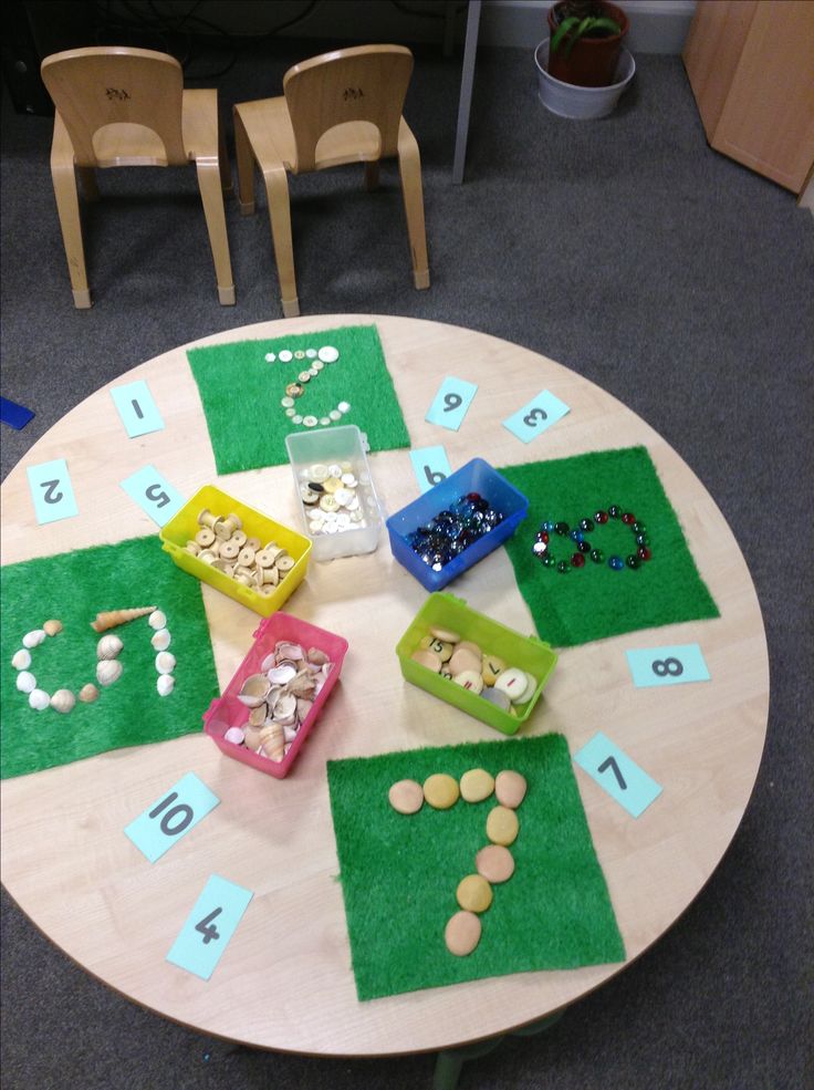 a wooden table topped with lots of different types of beads and numbers on top of it