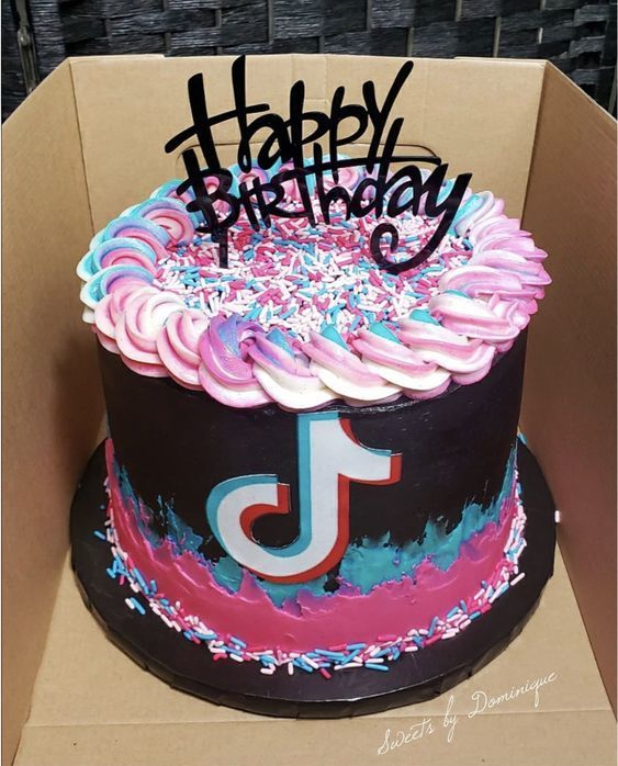 a birthday cake in a box with the letter j on it and sprinkles