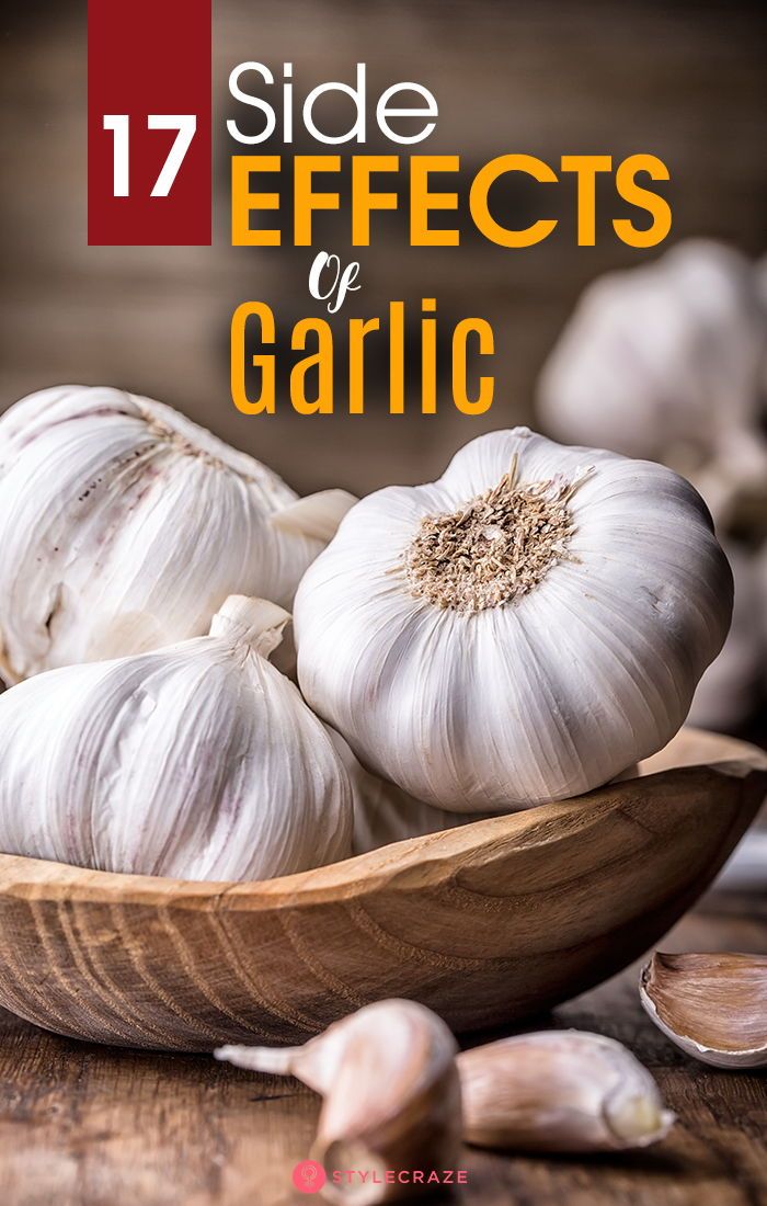 garlic bulbs in a wooden bowl with text overlay that reads, 17 side effects of garlic