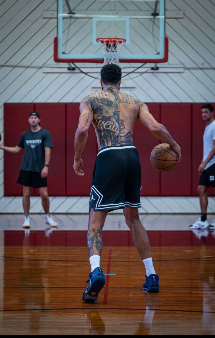 a man with tattoos on his back playing basketball