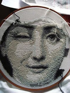 a close up of a person's face on a piece of cloth with thread