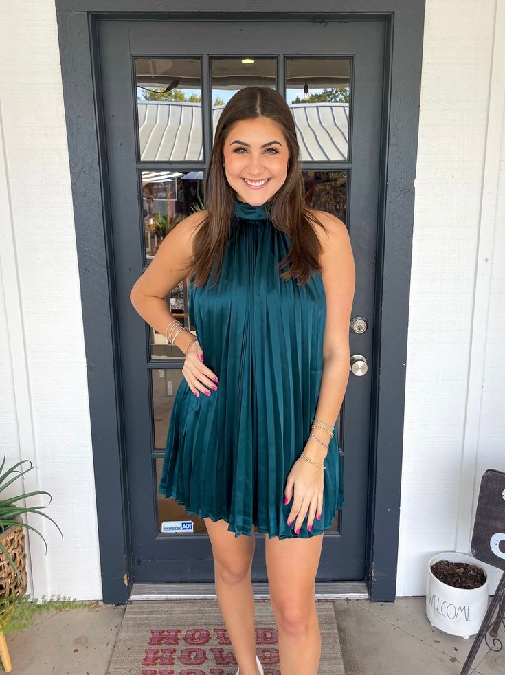 This dress is perfect for any occasion. Constructed with an all-over pleated design and a halter neck with a tie detail, it is both stylish and comfortable. Lined with satin, it is sure to be a go-to in your wardrobe. Thais is wearing a size Medium. Height is 5’10, Bust is 34”, Waist 27”, and Hips 38”. Spring Date Night Satin Halter Dress, Spring Satin Halter Dress For Date Night, Chic Satin Halter Dress For Spring, Spring Halter Neck Satin Dress For Night Out, Chic Spring Satin Halter Neck Dress, Pleated Halter Neck Dress For Date Night, Pleated Satin Mini Dress, Chic Sleeveless Pleated Dress For Date Night, Summer Dressy Pleated Dress