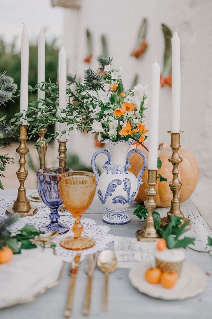 a table topped with lots of candles and plates