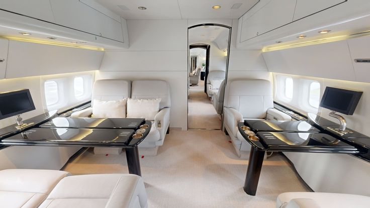 the inside of an airplane with couches and tables