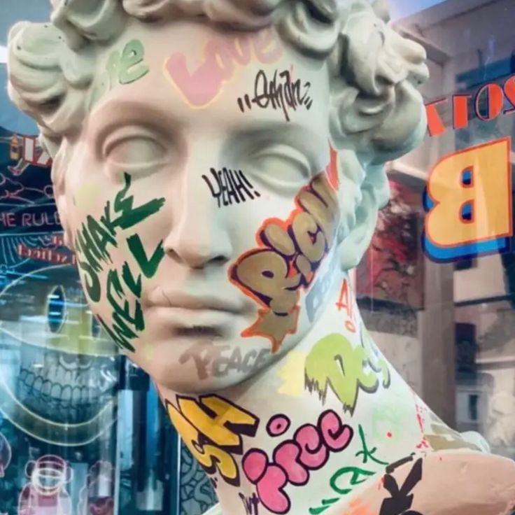 there is a statue that has been decorated with graffiti