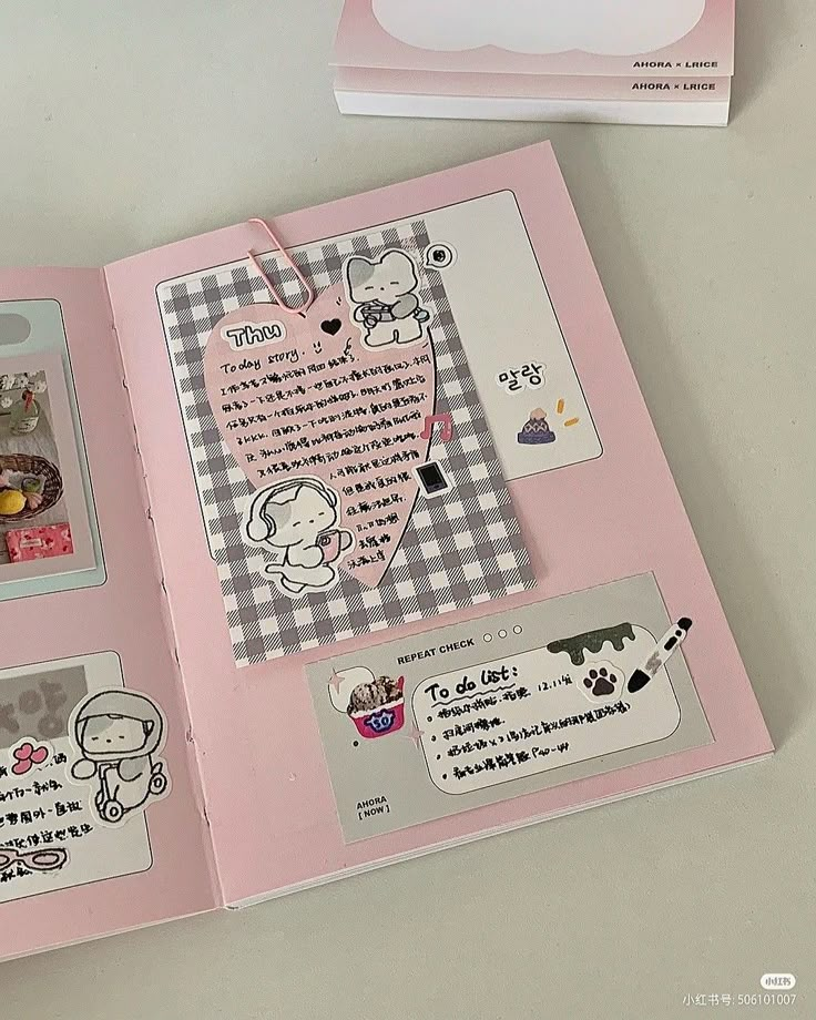 an open pink book with stickers and pictures on the pages is sitting on a table