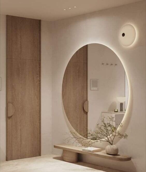 a round mirror sitting on top of a wooden shelf next to a white countertop