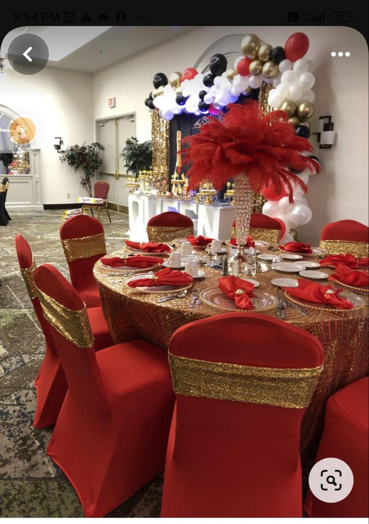 a table set up for a party with red and gold chairs