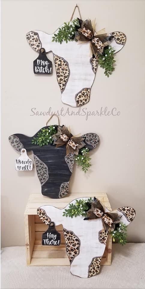 two cow heads are mounted on the wall above a wooden crate with plants in it