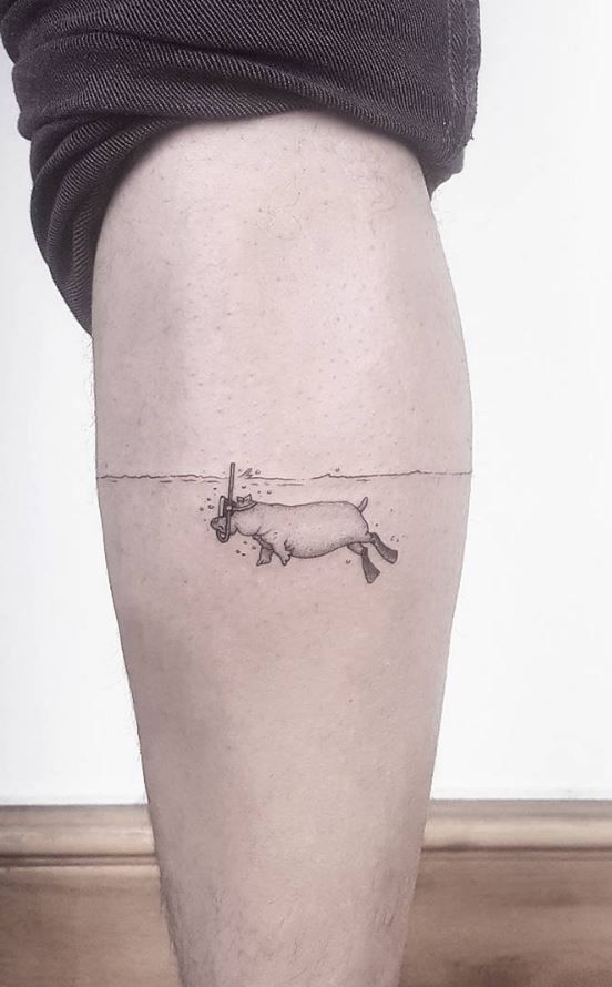 a man's leg with a small pig tattoo on it