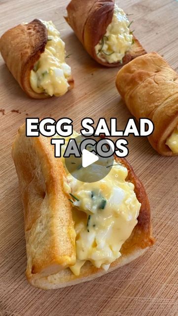 an egg salad in a croissant on a cutting board with the words egg salad tacos