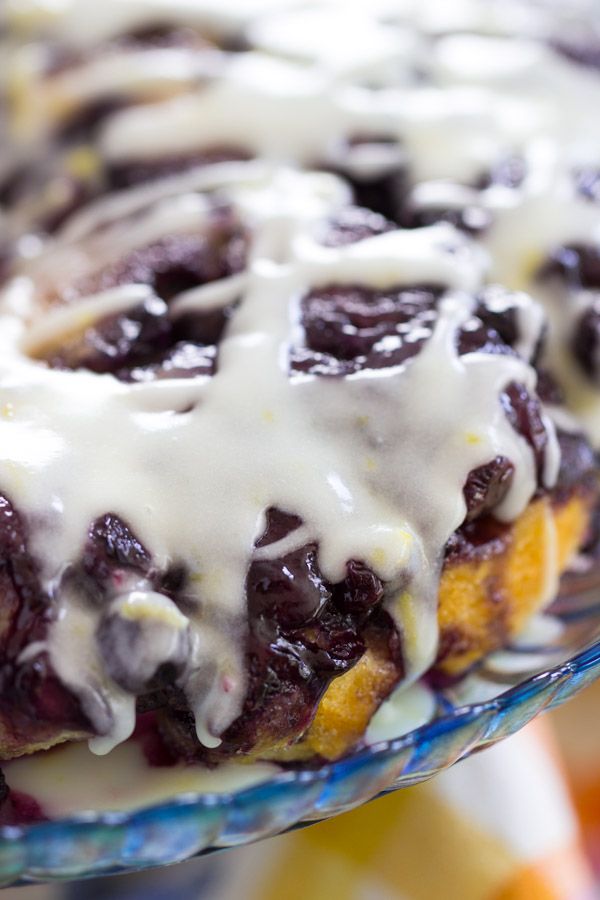 a close up of a plate of food with blueberries and cream drizzled on top